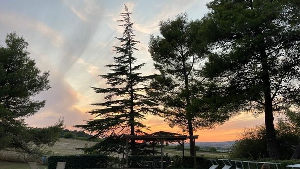A swimming pool with lounge chairs and a pergola, surrounded by trees and a sunset view. - Villa degli Scoiattoli, 200-m² villa for 8-10 people with park and swimming pool (Casette D'ete, FM)