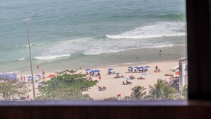 Una playa con sombrillas y gente.