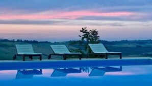 A pool with lounge chairs and a view of the landscape.