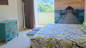A bedroom with a bed, a dresser, a window with curtains, and a mural of a pier and ocean. - Seaside, heart of Batu Ferringhi beach, luxury home stay  (Tanjung Bungah)