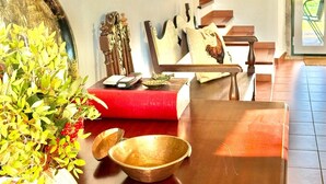 Una sala de estar moderna con un sofá rojo, una mesa de centro de madera y un espejo grande en la pared.