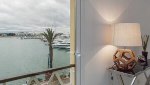A balcony with a view of a marina, a lamp, and a camera on a table.