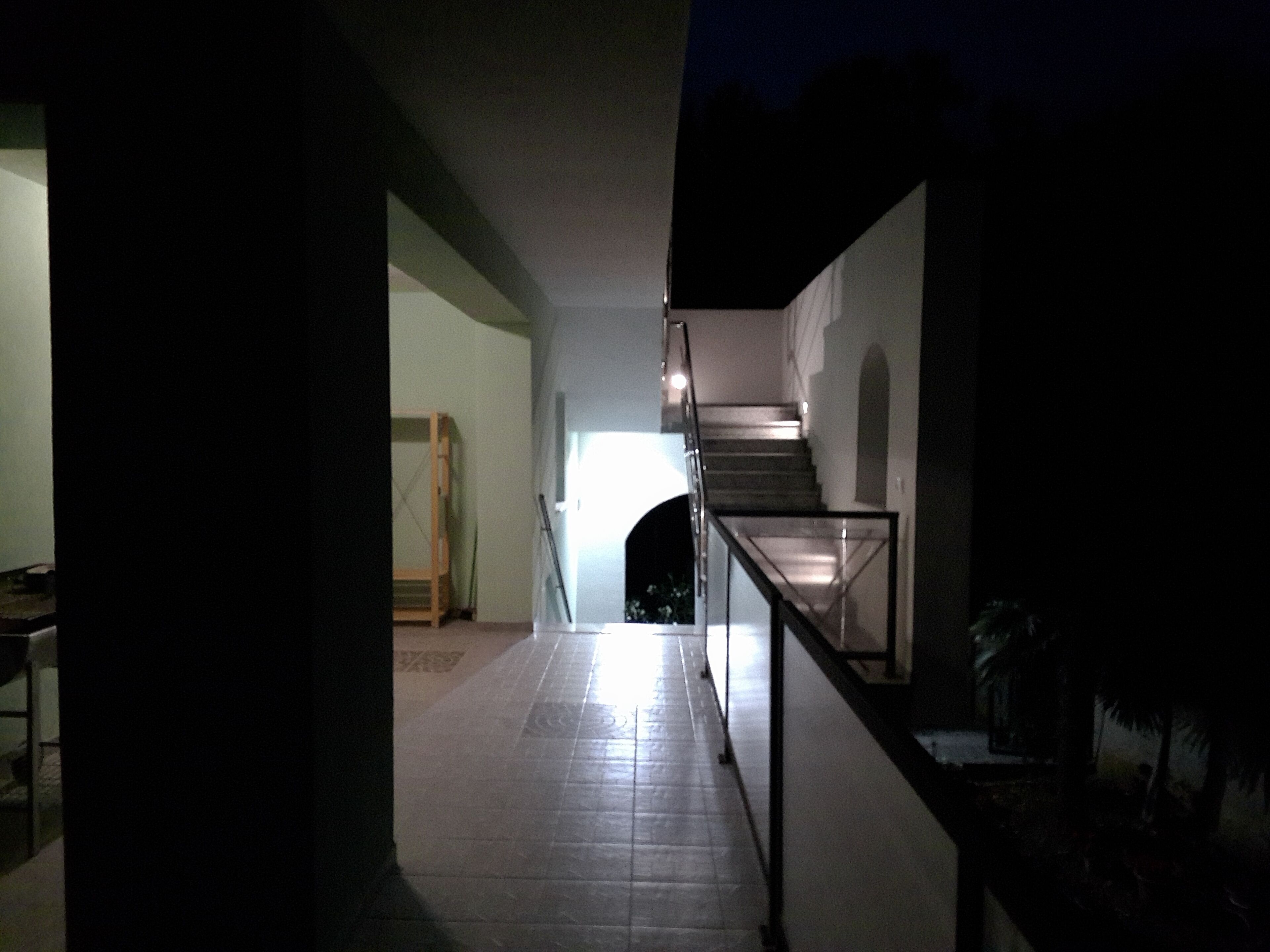 A dimly lit hallway with a staircase leading to a landing.