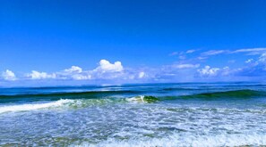 Una playa con olas y cielo despejado.