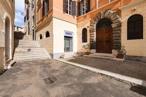 Un immeuble avec une façade en pierre, une porte en bois et une enseigne sur laquelle on peut lire « COLDWELL BANKER ».