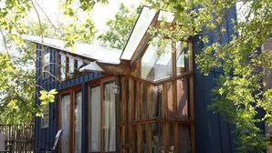 Une maison moderne dotée de grandes fenêtres et d’un toit en pente.