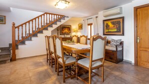 A dining area with a wooden staircase, a dining table with chairs, and a sofa. - FINCA MARINA  VT/121 ref. VP11 (Pollensa / Pollença)
