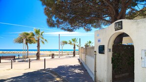 A coastal walkway with benches, palm trees, and a clear view of the beach. - Beachfront apartment perfect for families - UHC GLADIOLS 211 (Cambrils)