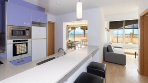 A modern kitchen with a central island, built-in appliances, and a view to a patio area. - Beachfront apartment perfect for families - UHC GLADIOLS 211 (Cambrils)