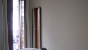 Een hotelkamer met een bed, een grote spiegel en uitzicht.