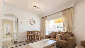 Un salon moderne avec un canapé, une table basse et un coin repas.