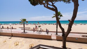 Une plage avec des palmiers, des gens et des parasols.