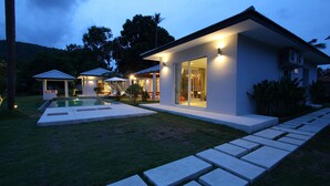 A modern house with a swimming pool, a patio, and a well-maintained lawn. - A Luxurious Retreat in Bophut (koh samui)