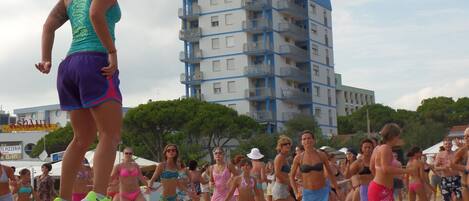 A beach event with a stage and a crowd.