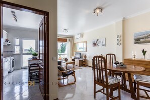 A modern kitchen with white cabinets and a dining area with wooden furniture.
