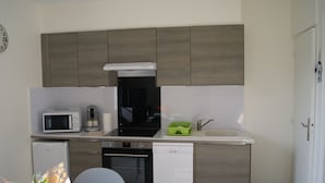 A compact kitchen with a microwave, coffee maker, and dishwasher. - Asylum Single Apartment (Mers-Les-Bains)