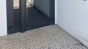 Une entrée moderne avec une porte en verre et un système de verrouillage à clavier numérique en métal.
