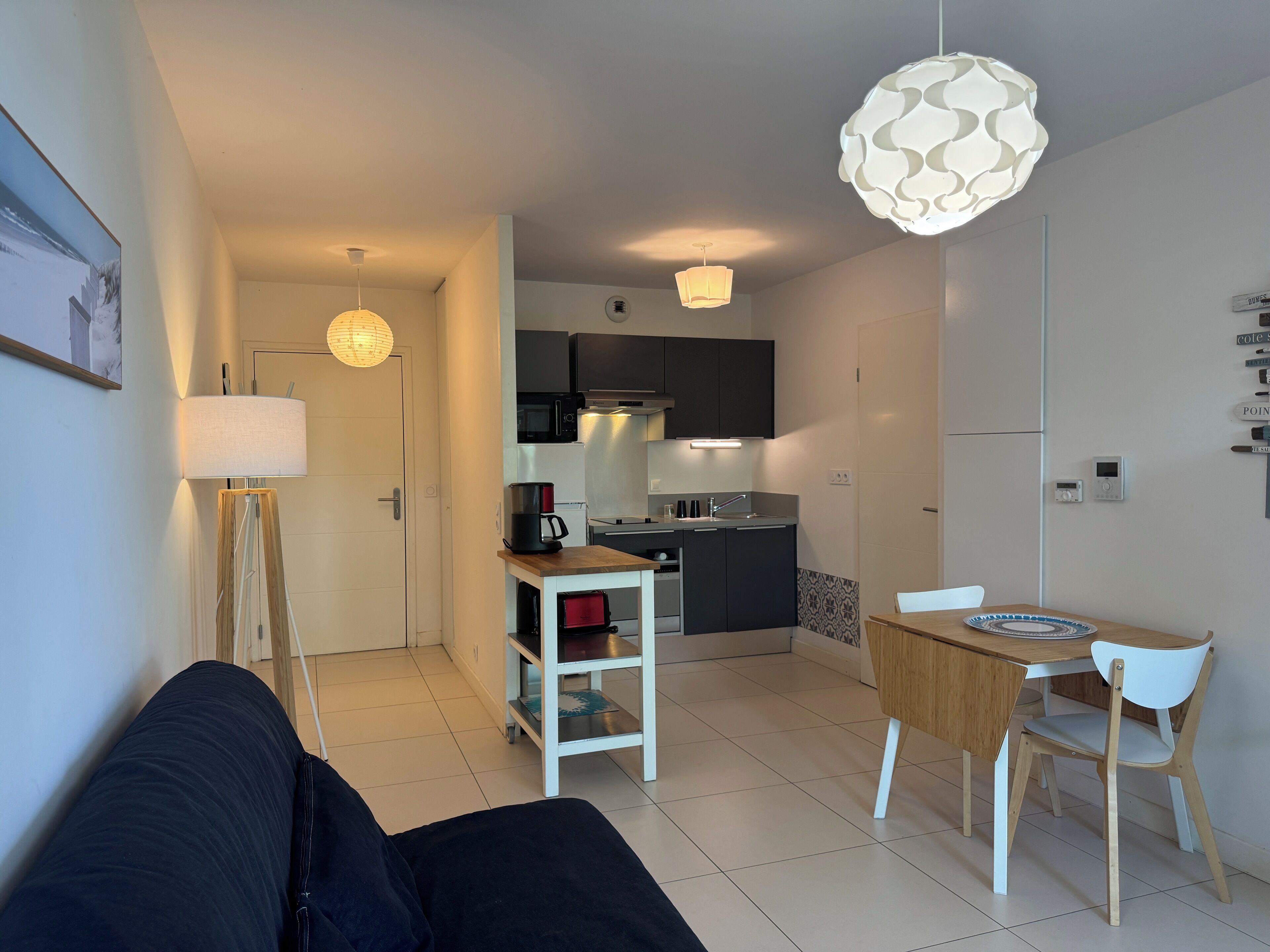 Eine moderne Küche mit Essbereich, einer Couch und einer Lampe.