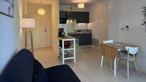 Une cuisine moderne avec un coin repas, un canapé et une lampe.