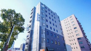 Un immeuble à plusieurs étages doté d’une architecture moderne, caractérisé par un mélange d’éléments de façade en verre et d’autres éléments massifs.