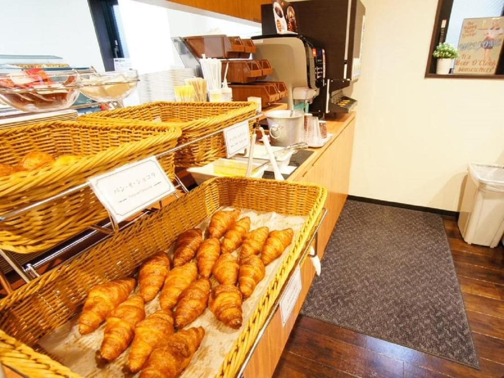 A bakery display with baskets of pastries and a coffee machine.