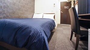 Une chambre d’hôtel avec un lit, un bureau et une porte.