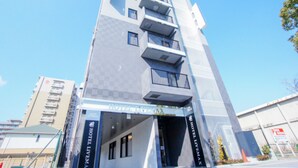 Un hôtel moderne avec une façade imposante, de nombreux balcons et un ciel dégagé.