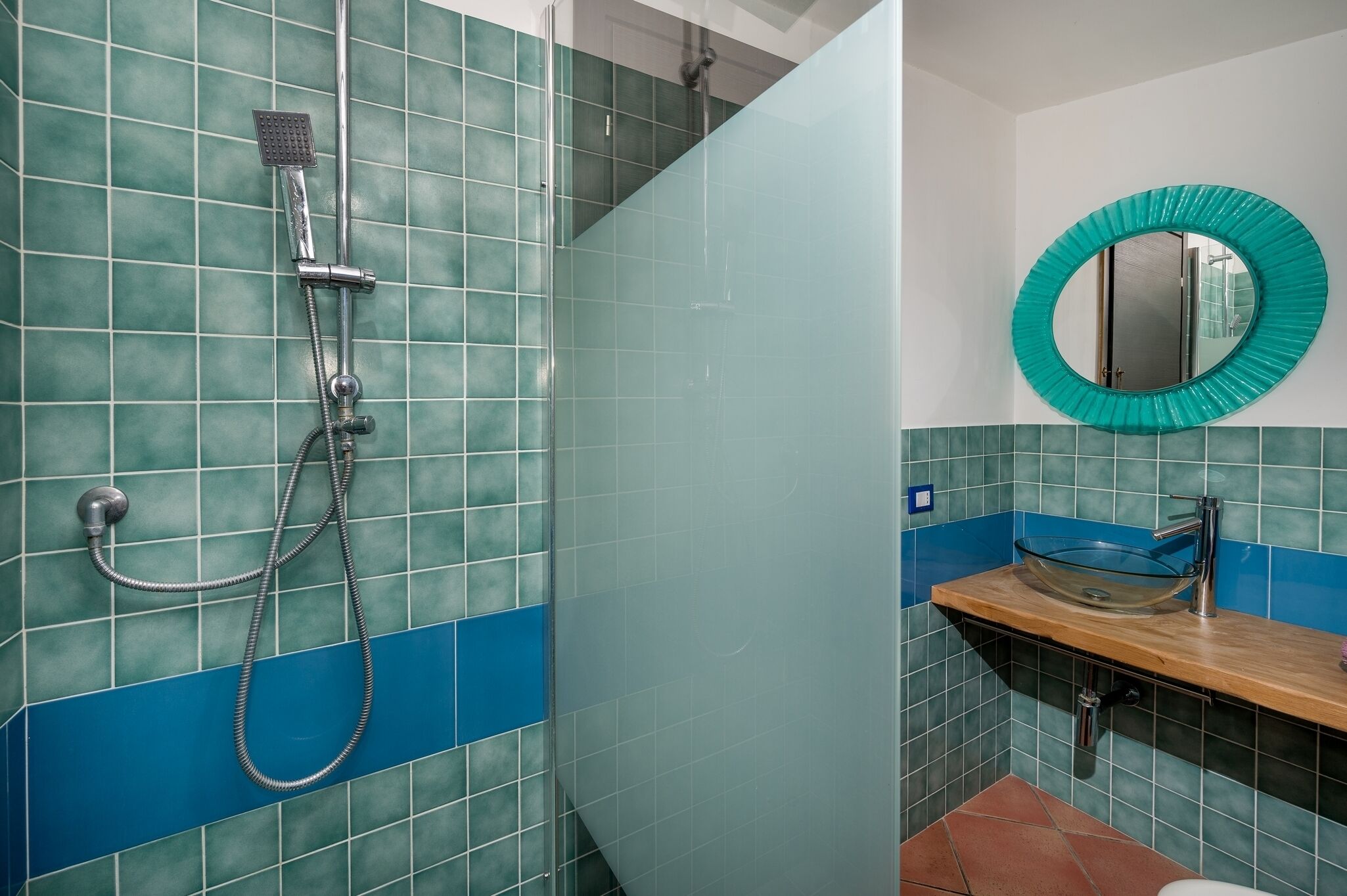 A bathroom with a shower, a sink, and a mirror.