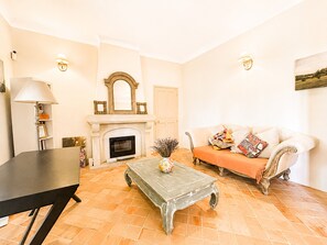 Ein Wohnzimmer mit Kamin, Sofa, Couchtisch und Lampe.