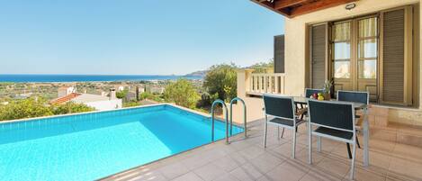 Ein Pool mit Meerblick, Sitzgelegenheiten im Freien und eine Pergola.