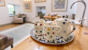 Una mesa de comedor con un juego de té y una bandeja estampada.