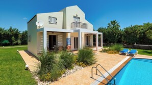 Une maison moderne dotée d’une piscine, d’un espace salon extérieur et d’une antenne parabolique.
