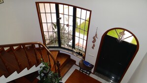 A staircase with a wooden handrail leading to a landing with a potted plant.