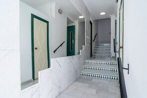 Eine Treppe mit weißen Marmorstufen und türgrünen Rahmen.