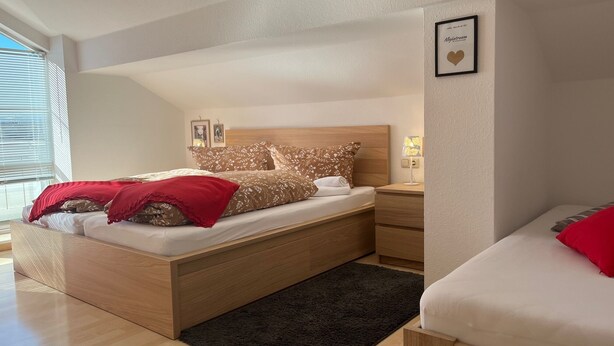 A modern bedroom with a wooden bed, a bedside table, and a small bedside lamp.