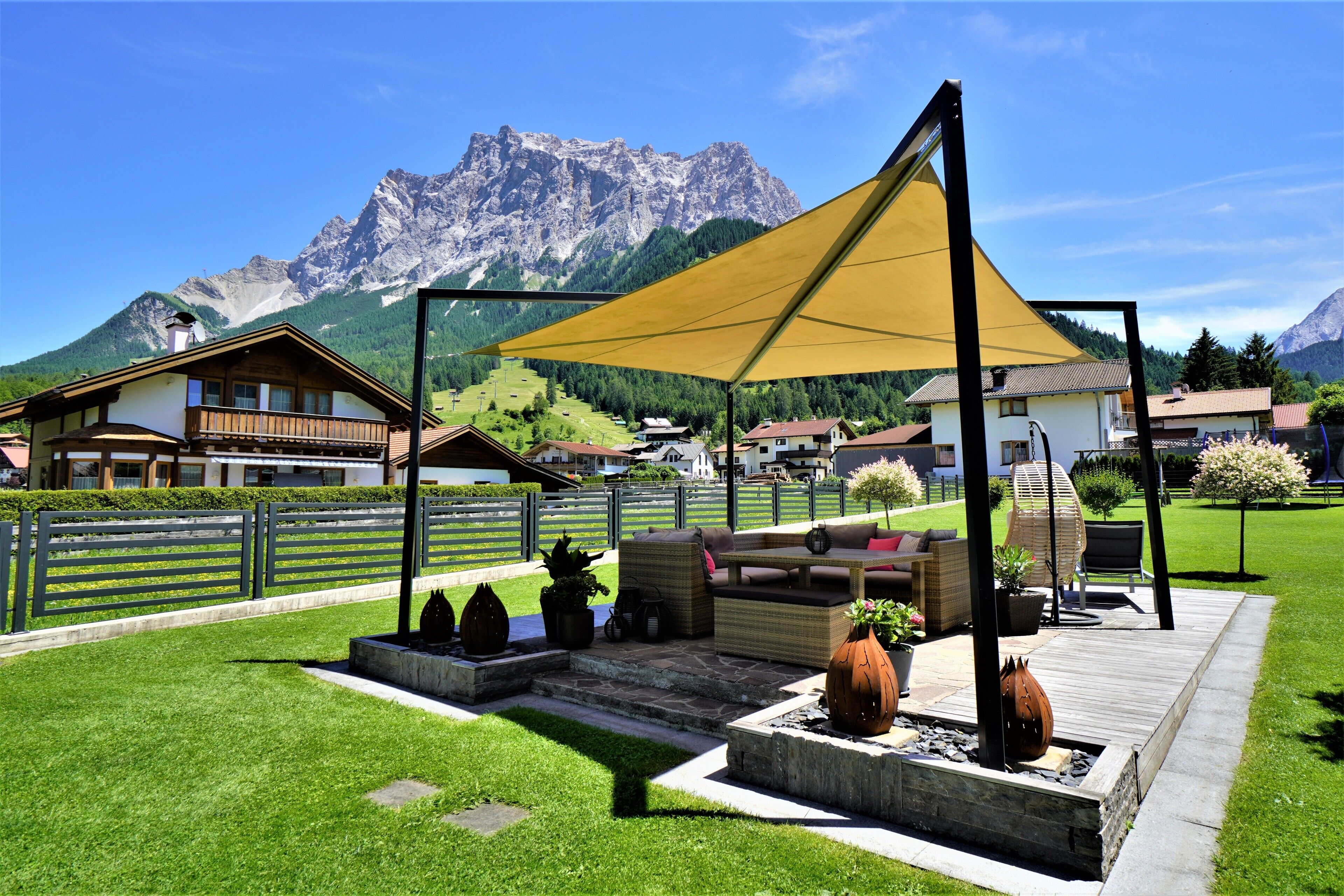 Un espace patio aménagé avec du mobilier d’extérieur, une terrasse en bois et une vue imprenable sur les montagnes.