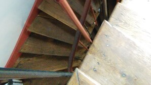 Een houten trap met metalen leuningen.