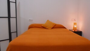 A room with a bed, a nightstand, a lamp, and a ladder against the wall. - Nice loft in downtown Seville (Sevilla)