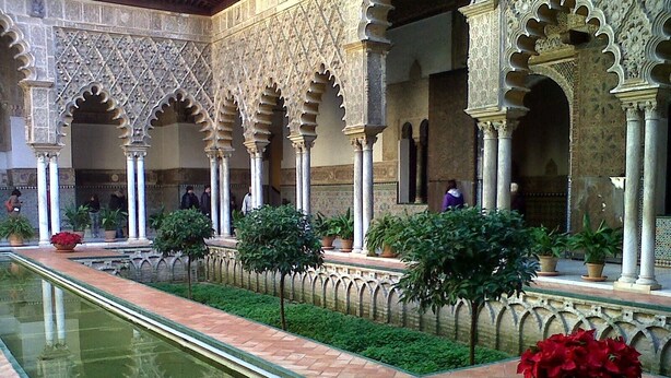 An indoor courtyard with a reflective pool, columns, and potted plants. - Nice loft in downtown Seville (Sevilla)