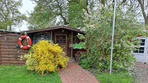 Eine Holzhütte mit einem Ziegelweg, der zum Eingang führt.