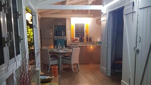 A spacious kitchen with a dining area, wooden flooring, and a view of the backyard. - CocosunLodge * superb sea view and private pool * (TROIS ILETS)