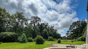 En stenbænk med buet ryg i en park.