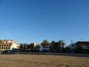 Una playa con edificios al fondo, incluyendo un hotel llamado "Los Angeles".