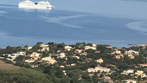 A cruise ship on a calm sea with a coastal town in the background. - AJACCIO Furnished apartment with breathtaking sea view, facing Marinella beach. (Ajaccio)