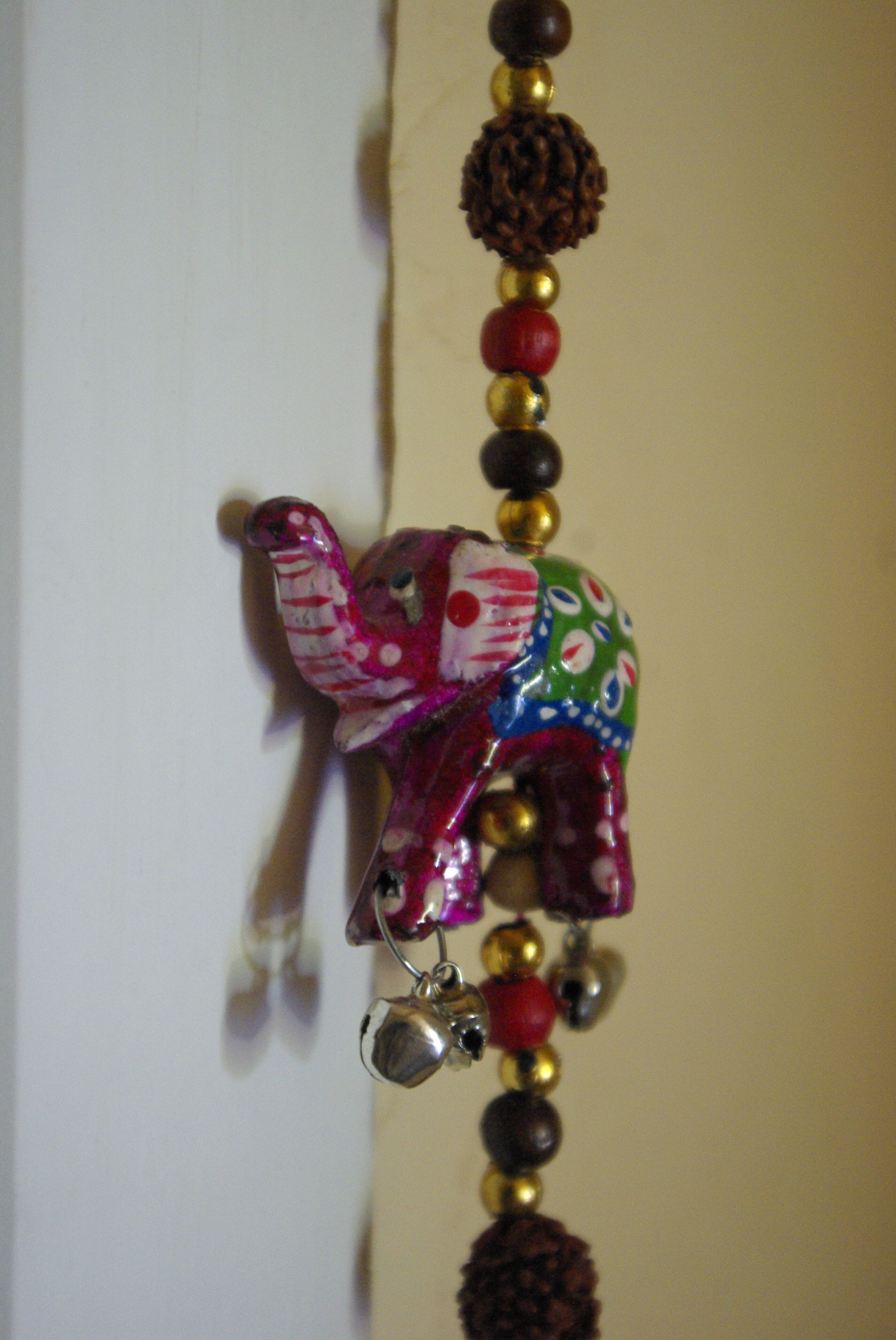 Un adorno decorativo de elefante con cuentas y cascabeles.