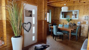 A wooden interior with a dining area, a heart-shaped decoration on the door, and a potted plant. - La Clusaz skiing and biking (La Clusaz)