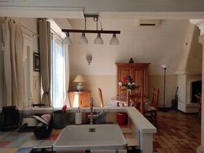 A well-lit kitchen with a sink, cabinets, and a dining area with chairs. - Quiet house not overlooked, 30 m2 terrace 200 meters from the ramparts  (Avignon)