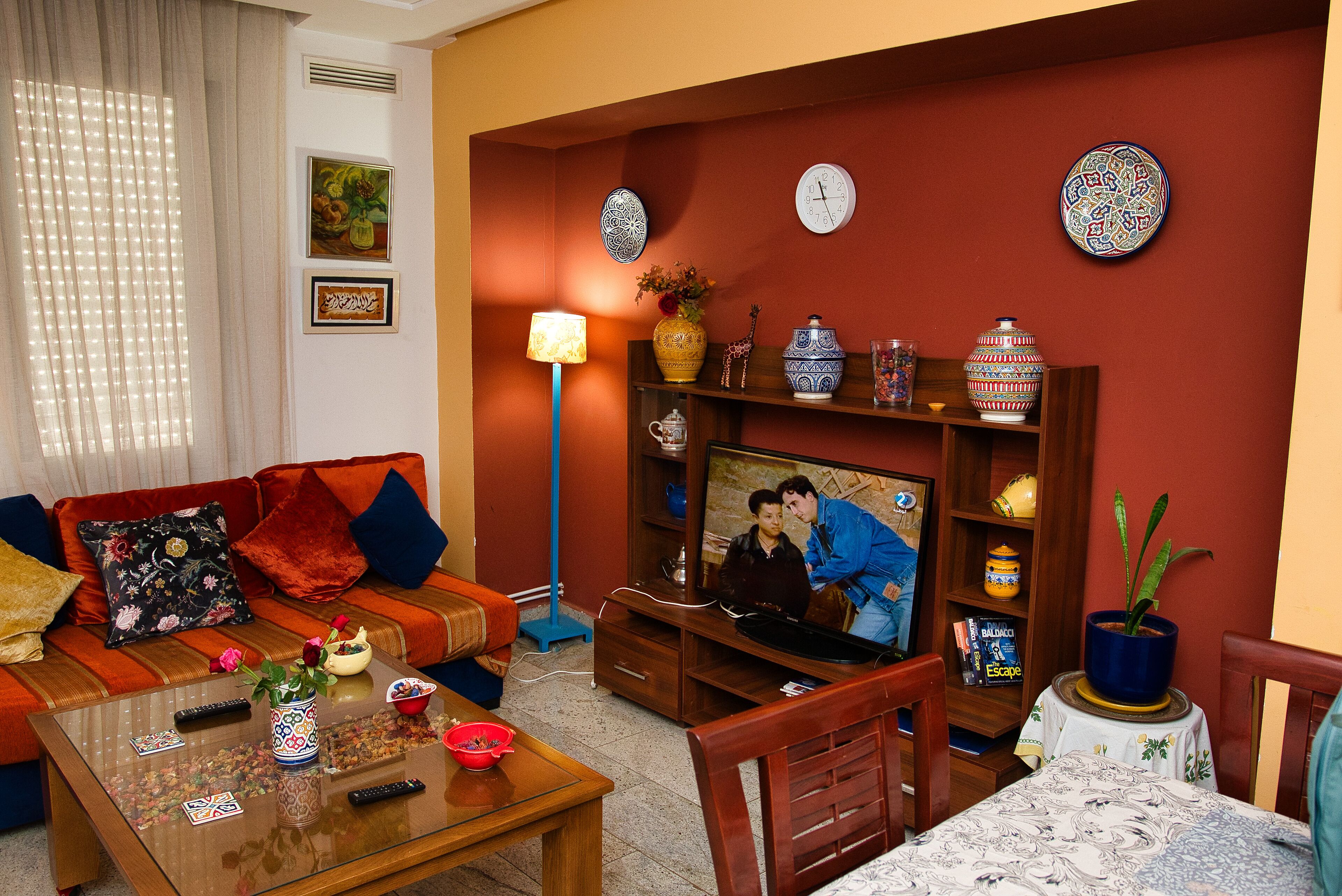 A living room with a sofa, coffee table, TV, and decorative items.