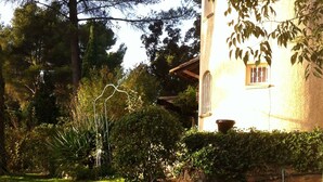 Un jardin avec un chemin de pierre menant à un bâtiment doté d’une fenêtre.
