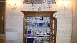 A room with a wooden cabinet containing various glassware and dishes. - Claire s' house in medieval village couze near river Dordogne with your pets (Couze)